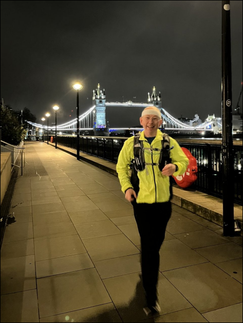 Paul running in the dark - cold weather clothing with dayglo jacket - Tower Bridge in the background - nicely illuminated - the footpath in the foreground has good street lighting