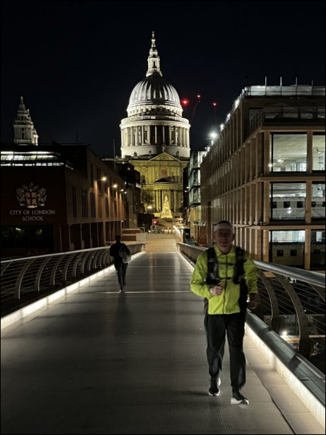 Paul running in the dark on Millenium Bridge - cold weather clothing with dayglo jacket - Saint Pauls Cathedral in the background - nicely illuminated - the footpath in the foreground has low level lighting which is less than ideal